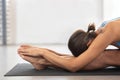 Brunette woman doing stretching workout exercises while sitting on the floor, yoga