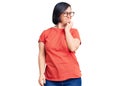 Brunette woman with down syndrome wearing casual clothes and glasses looking stressed and nervous with hands on mouth biting nails Royalty Free Stock Photo