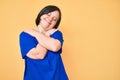 Brunette woman with down syndrome wearing casual clothes hugging oneself happy and positive, smiling confident Royalty Free Stock Photo