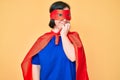Brunette woman with down syndrome wearing super hero costume looking stressed and nervous with hands on mouth biting nails Royalty Free Stock Photo