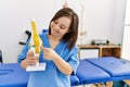 Brunette woman with down syndrome working holding anatomical knee at physiotherapy clinic Royalty Free Stock Photo