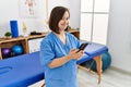 Brunette woman with down syndrome working using smartphone at physiotherapy clinic Royalty Free Stock Photo