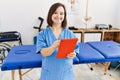 Brunette woman with down syndrome working using tablet at physiotherapy clinic Royalty Free Stock Photo