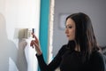 Brunette woman entering security pin on home alarm keypad Royalty Free Stock Photo