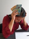 brunette woman with expression of despair and grabbing New Zealand money Royalty Free Stock Photo