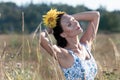 Brunette woman in the field, sunflower in her hair, sunny day, she is in a summer sundress. Royalty Free Stock Photo
