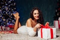 Beautiful brunette woman with gifts at the Christmas tree lights garlands new year Royalty Free Stock Photo