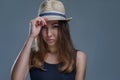 Beautiful woman in hat and black shirt is posing stylishly isolated on gray background in a studio close up Royalty Free Stock Photo