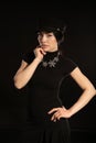 a brunette woman in a hat poses on a black background Royalty Free Stock Photo