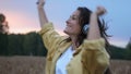 Brunette woman in headphones dancing in wheat field in summer sunset time Royalty Free Stock Photo