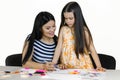 Brunette woman and her daughter at the desk are drawing something together. Royalty Free Stock Photo