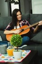 Brunette woman at home playing the guitar Royalty Free Stock Photo