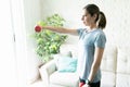 Brunette woman lifting weights at home