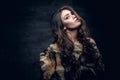 Brunette woman with long curly hair dressed in a fur coat. Royalty Free Stock Photo