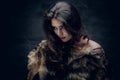 Brunette woman with long curly hair dressed in a fur coat. Royalty Free Stock Photo