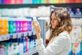 Brunette woman choses deodorant in household goods store Royalty Free Stock Photo