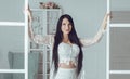 Brunette woman with long hair opening doors in living room Royalty Free Stock Photo