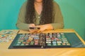 Brunette woman with a magnifying glass looking through her philatelic collection