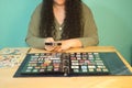 Brunette woman with a magnifying glass looking through her philatelic collection