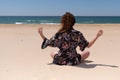 Brunette woman meditation in a yoga pose at sand beach Royalty Free Stock Photo