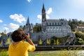 Woman photographs the cathedral in Lourdes, France