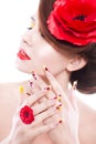 Brunette woman with poppy flower in her hair, poppy ring and creative nails, closed eyes