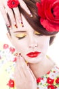 Brunette woman with poppy flower in her hair, poppy ring and creative nails, closed eyes