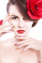 Brunette woman with poppy flower in her hair, poppy ring and creative nails, closed eyes