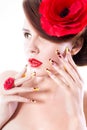 Brunette woman with poppy flower in her hair, poppy ring and creative nails