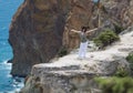 Brunette woman posing on cliff with arms outstretched Royalty Free Stock Photo