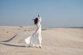 Brunette woman posing in windy desert in white light wedding dress Royalty Free Stock Photo