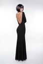 Brunette woman with back in black long dress