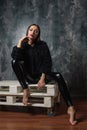 Brunette woman sitting on wooden pallet couch .