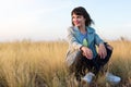 Brunette woman sitting in yellow steppe grass