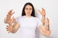 A brunette woman with six arms in a white T-shirt. Many hands, meditation with your eyes closed. Royalty Free Stock Photo