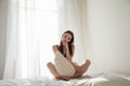 Brunette woman after sleeping in bedroom pillows on the bed