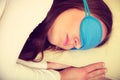 Brunette woman sleeping in blue eye sleep mask Royalty Free Stock Photo