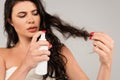 brunette woman spraying treatment product on