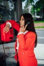 a brunette woman talking on the phone in a booth on the street Royalty Free Stock Photo