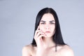 Brunette woman touching her cheek by hand and looking straight. Beauty concept Royalty Free Stock Photo