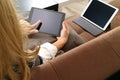 brunette woman using digital talet and laptop computer on sofa i Royalty Free Stock Photo