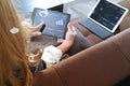 brunette woman using digital talet and laptop computer on sofa i Royalty Free Stock Photo