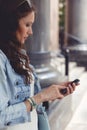 Brunette woman using her smartphone outdoors