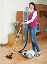 Brunette woman vacuuming living room