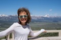 Brunette woman with wavy hair poses at the Galena Summit in the Frank Church Wiilderness of Sawtooth Mountains in Idaho