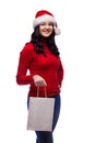 brunette woman wearing christmas hat holding present bag with a happy face. Isolated Royalty Free Stock Photo