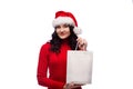 Brunette woman wearing christmas hat holding present with a happy face. Isolated Royalty Free Stock Photo