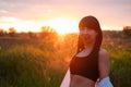 brunette woman in white blouse with baldric on summer field on sunset. peaceful time. millennial generation. calm female