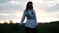 brunette woman in white blouse with baldric on summer field on sunset. peaceful time. millennial generation. calm female