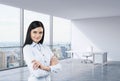 A brunette woman in a workplace at modern corner panoramic office in New York, Manhattan. A concept of financial consulti